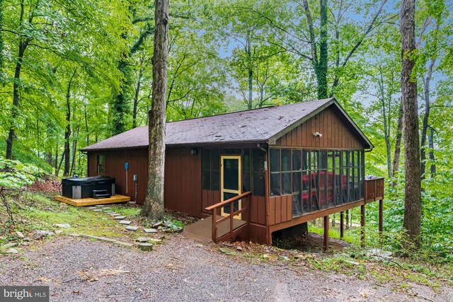 view of front of home with a hot tub and a sunroom