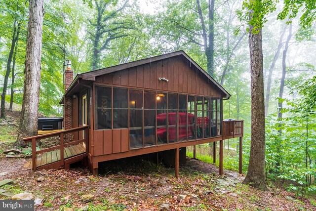 rear view of house featuring a sunroom and a chimney
