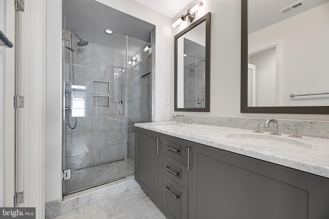 bathroom featuring a marble finish shower, marble finish floor, visible vents, and a sink