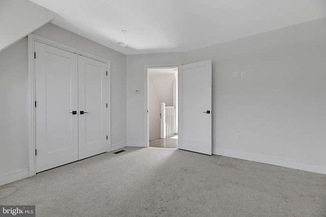 unfurnished bedroom featuring baseboards, a closet, and carpet