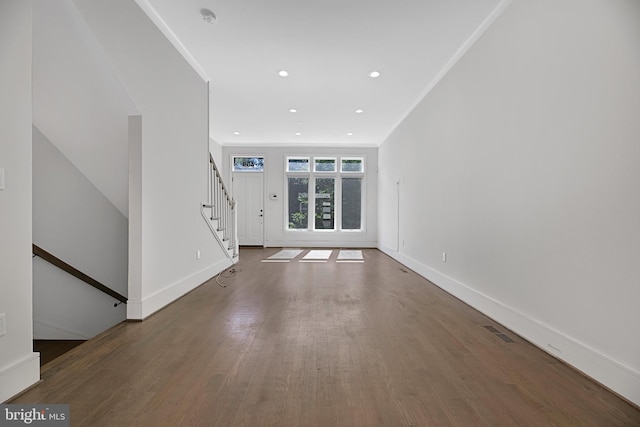 unfurnished living room with stairway, baseboards, visible vents, and wood finished floors