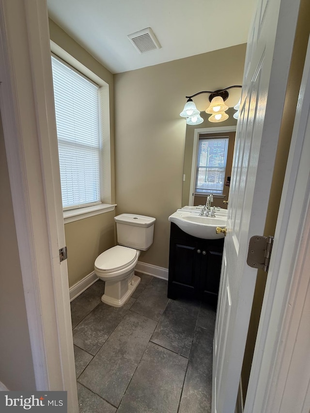 bathroom with toilet, baseboards, and vanity