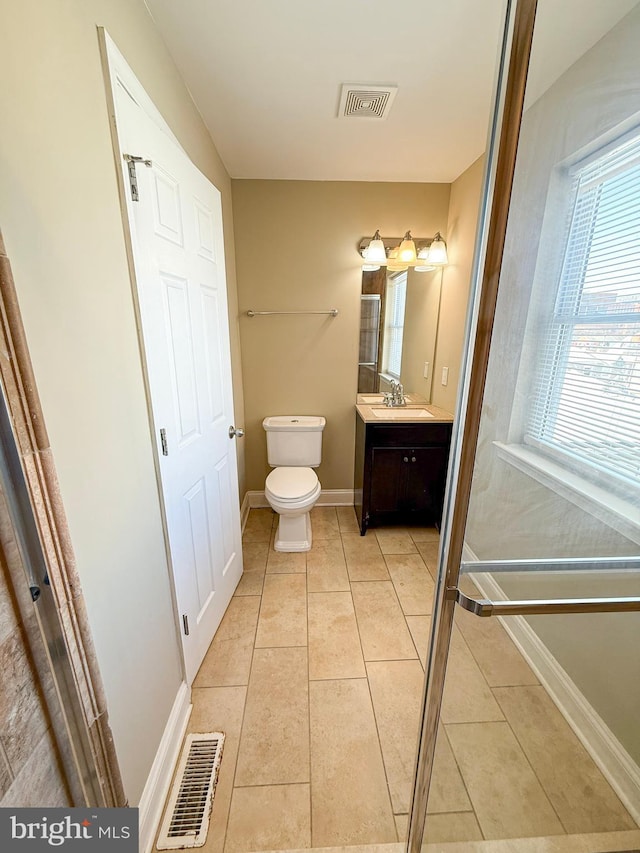 bathroom featuring toilet, tile patterned floors, baseboards, and vanity