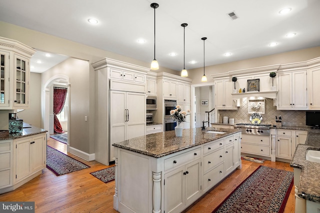 107 Centrenest Ln, Wilmington, DE 19807 - kitchen with built in appliances, light wood-style flooring, visible vents, and arched walkways