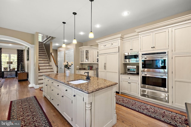 107 Centrenest Ln, Wilmington, DE 19807 - kitchen with built in appliances, light wood finished floors, a sink, arched walkways, and a warming drawer