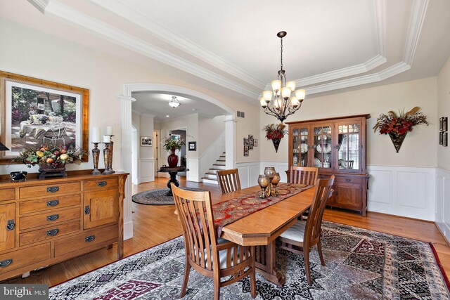 107 Centrenest Ln, Wilmington, DE 19807 - dining room with decorative columns, a notable chandelier, light wood-type flooring, arched walkways, and ornamental molding