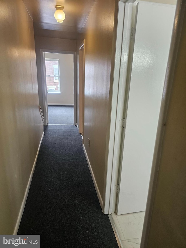 hall with baseboards and carpet floors