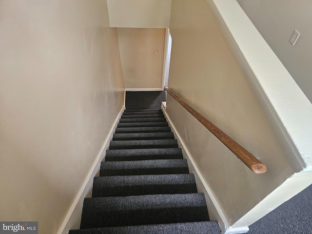 stairway featuring carpet flooring and baseboards