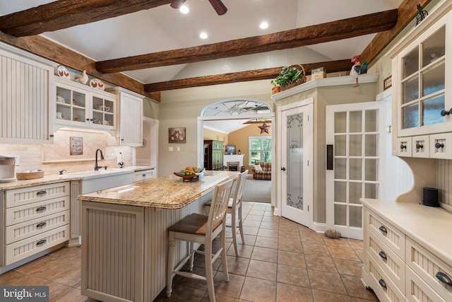 832 Muller Rd, Westminster, MD 21157 - kitchen with ceiling fan, decorative backsplash, a kitchen island, glass insert cabinets, and a kitchen bar