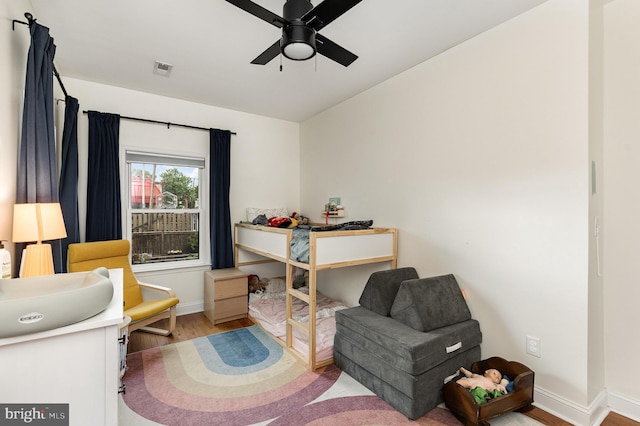 living area featuring vaulted ceiling, baseboards, visible vents, ceiling fan, and wood finished floors