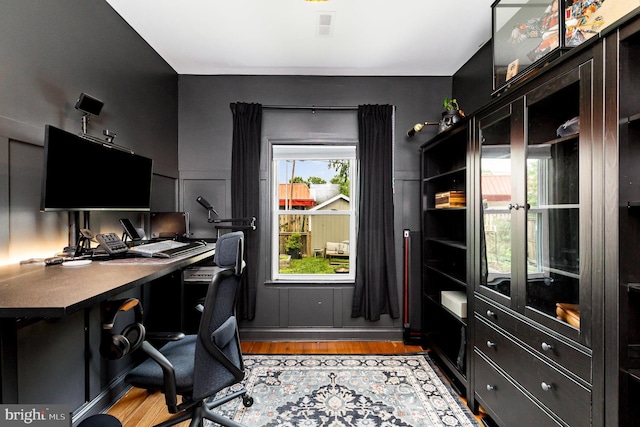 home office with visible vents and wood finished floors