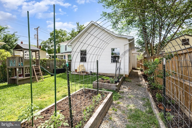 exterior space featuring a fenced backyard, a vegetable garden, and a playground