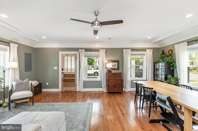 living area with crown molding, baseboards, hardwood / wood-style floors, and a ceiling fan