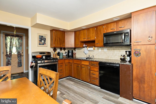 kitchen featuring black dishwasher, stainless steel gas stove, tasteful backsplash, and light wood-style floors