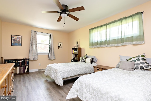 bedroom featuring wood finished floors, baseboards, and ceiling fan
