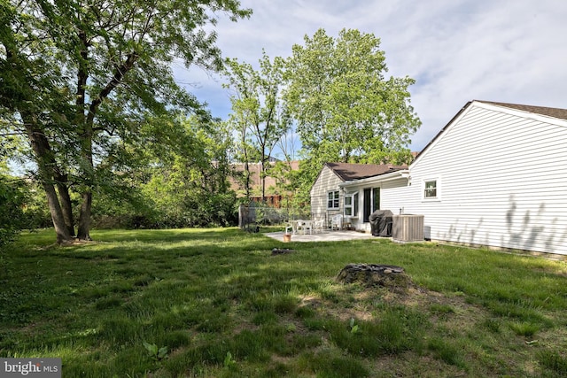 view of green lawn with a patio and central AC unit