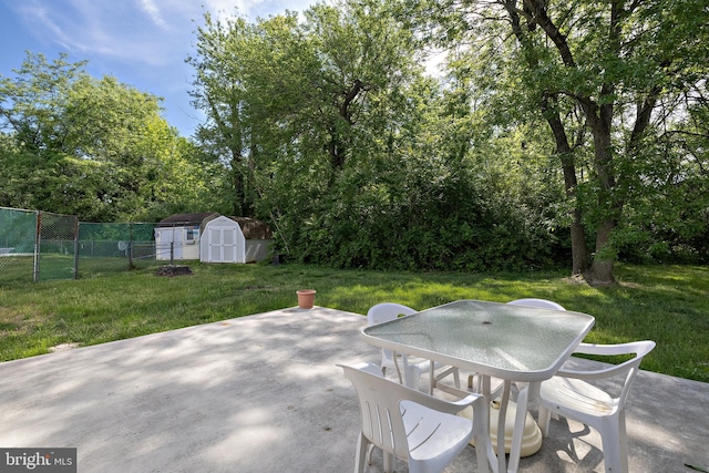 view of patio / terrace featuring a storage shed, outdoor dining area, and an outdoor structure