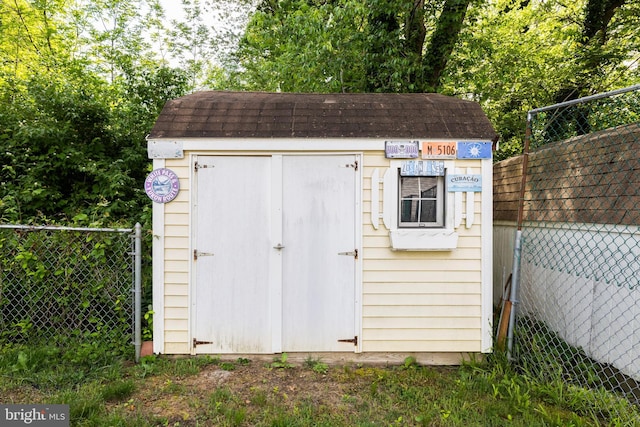 view of shed featuring fence
