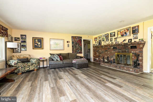 living room with wood finished floors and a brick fireplace