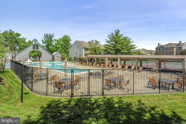 community pool with a yard, a patio, fence, and a residential view