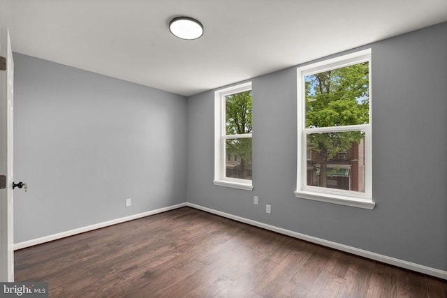 spare room featuring wood finished floors and baseboards
