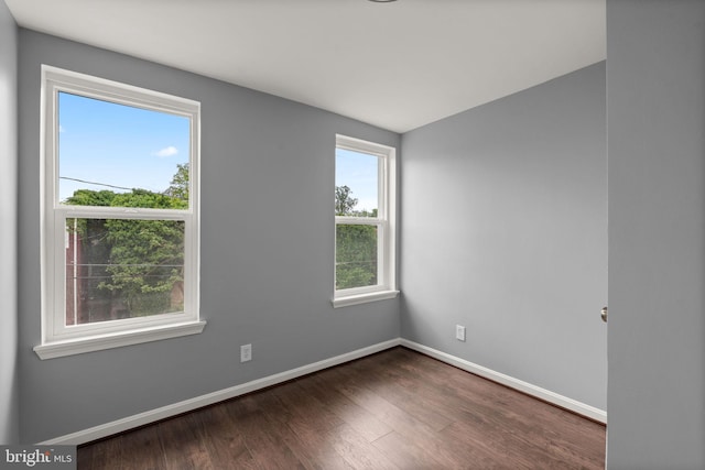unfurnished room featuring baseboards and wood finished floors