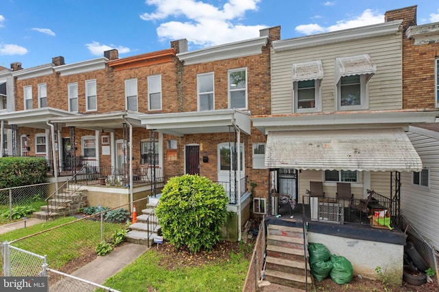 3011 W Lanvale St, Baltimore, MD 21216 - view of front facade featuring a porch, brick siding, and fence