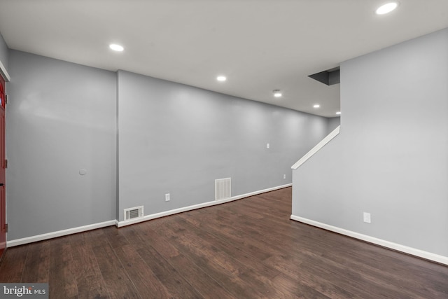 below grade area with wood finished floors, baseboards, recessed lighting, and stairs