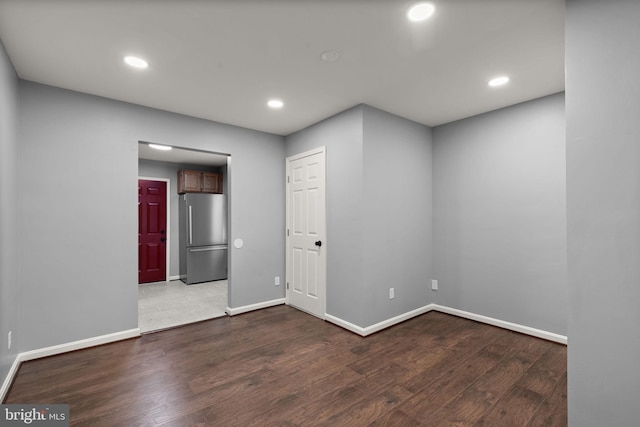 unfurnished room with wood finished floors, baseboards, and recessed lighting