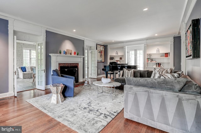 living area with a wealth of natural light, ornamental molding, and wood finished floors