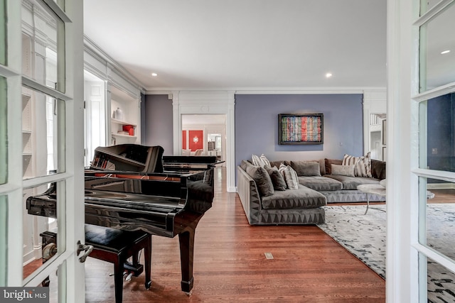 living area featuring recessed lighting, crown molding, and wood finished floors