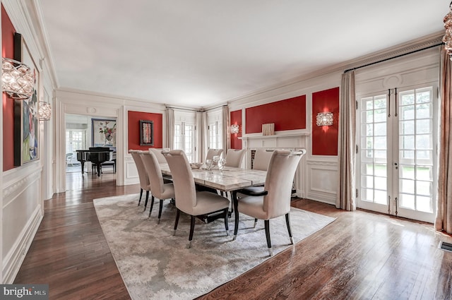 dining space with crown molding, a wealth of natural light, and a decorative wall