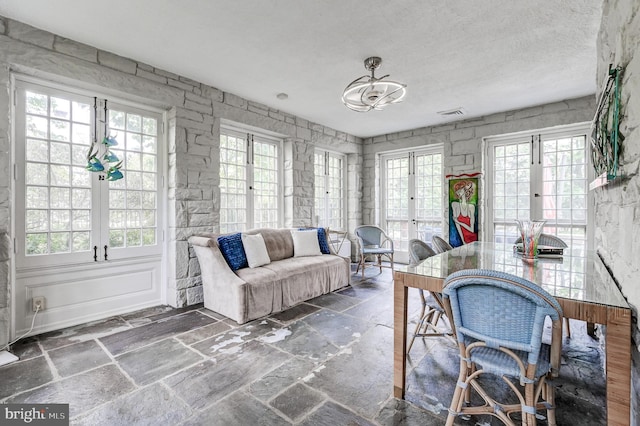 interior space featuring a chandelier, french doors, and visible vents