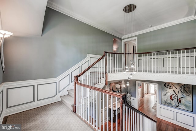 stairway featuring wood finished floors and ornamental molding