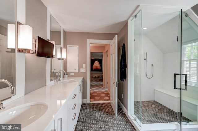 bathroom with double vanity, a stall shower, and a sink