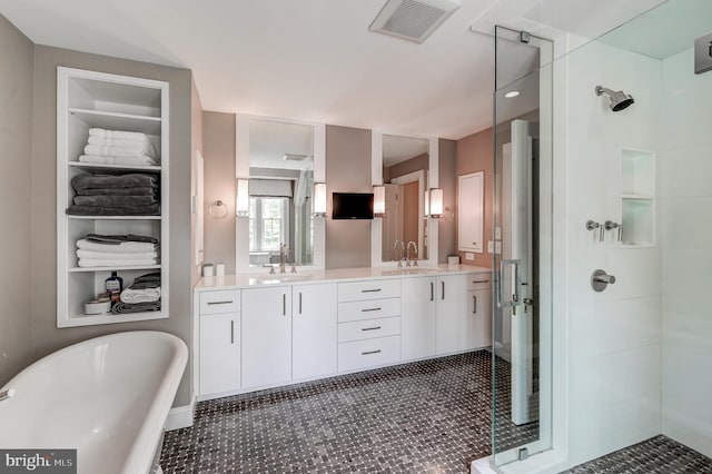 bathroom with a shower stall, a soaking tub, double vanity, and a sink