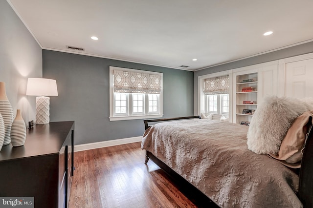 bedroom featuring recessed lighting, baseboards, ornamental molding, visible vents, and wood finished floors