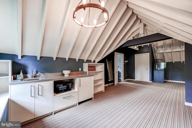 kitchen with a sink, lofted ceiling with beams, an inviting chandelier, carpet flooring, and white cabinets