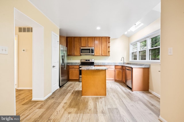 kitchen featuring light wood finished floors, open shelves, visible vents, appliances with stainless steel finishes, and a kitchen island