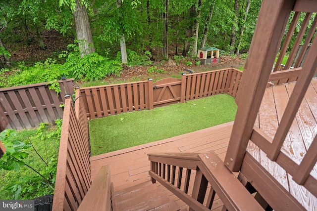 wooden deck featuring a fenced backyard and a gate