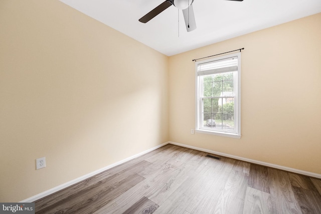 empty room featuring baseboards, visible vents, and wood finished floors