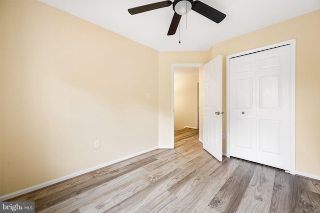 unfurnished bedroom featuring a closet, a ceiling fan, wood finished floors, and baseboards