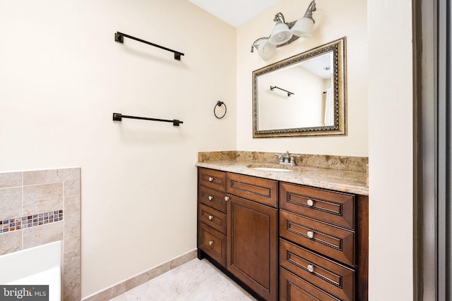 bathroom featuring vanity, a bathing tub, baseboards, and tile patterned floors