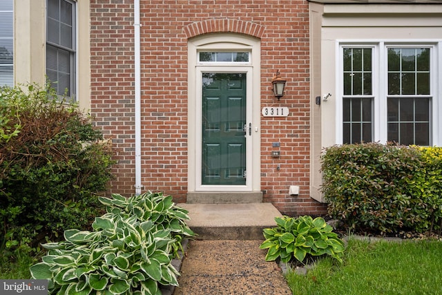 entrance to property featuring brick siding