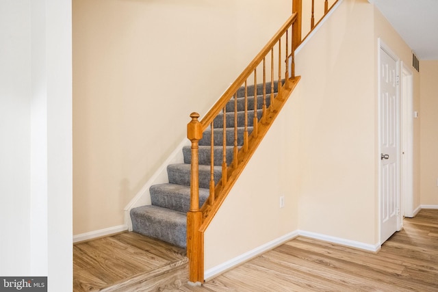stairway with baseboards and wood finished floors