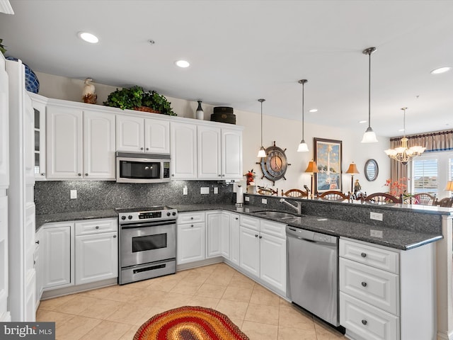 13000 Marina View Ln Unit 25, Ocean City, MD 21842 - kitchen featuring appliances with stainless steel finishes, a peninsula, a sink, backsplash, and a chandelier
