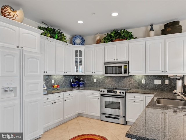 13000 Marina View Ln Unit 25, Ocean City, MD 21842 - kitchen with stainless steel appliances, a sink, dark stone countertops, light tile patterned flooring, and white cabinetry