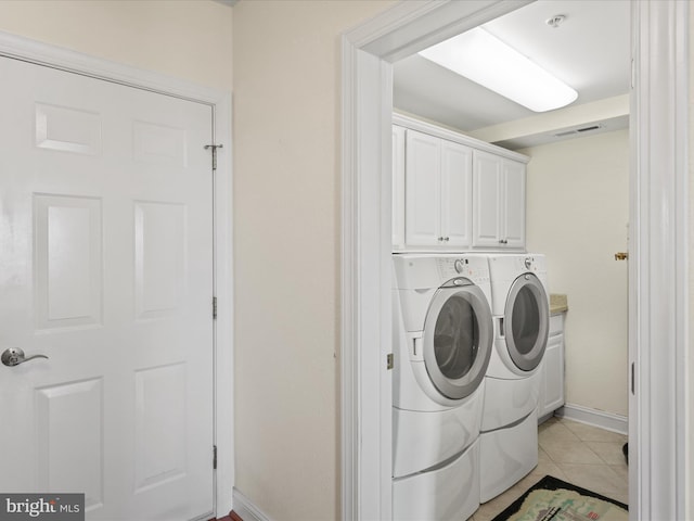 13000 Marina View Ln Unit 25, Ocean City, MD 21842 - washroom featuring washing machine and clothes dryer, baseboards, light tile patterned floors, and cabinet space