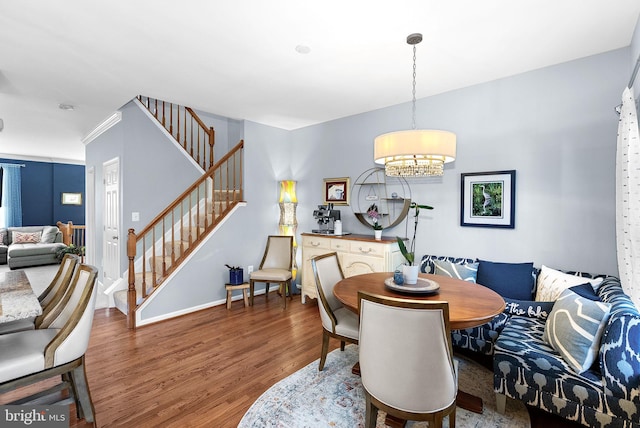 dining area with stairway, wood finished floors, a chandelier, and baseboards