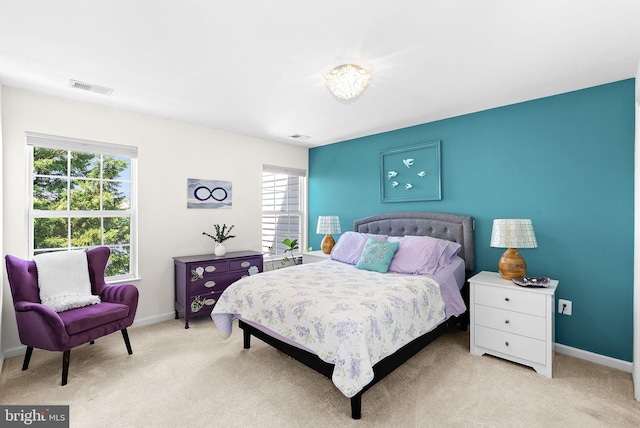 carpeted bedroom with multiple windows and baseboards